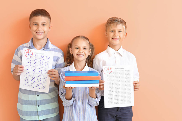 Szczęśliwe dzieci z arkuszami odpowiedzi do egzaminu szkolnego na kolorowym tle - Zdjęcie, obraz