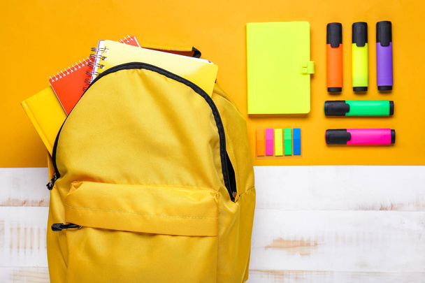 Mochila escolar y papelería sobre fondo de color - Foto, Imagen