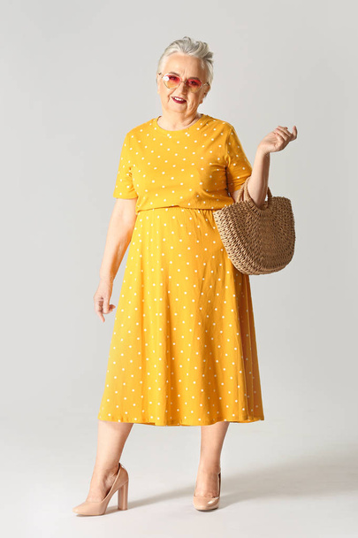Mujer de edad avanzada con estilo sobre fondo gris
 - Foto, Imagen