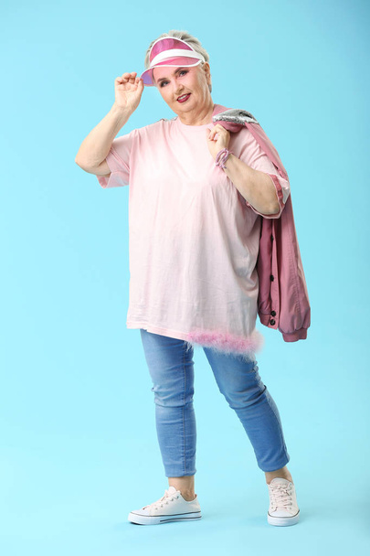 Stylish elderly woman on color background - Foto, afbeelding