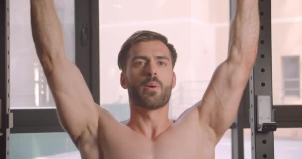 Yakışıklı gömleksiz kas beyaz adam powerlifting spor salonunda kapalı closeup portre - Video, Çekim