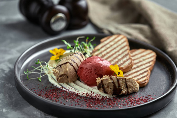 Duck paste with ice cream and grilled white bread croutons. Close-up, low key, gray background. - Φωτογραφία, εικόνα
