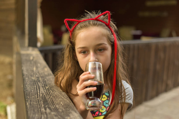 niña bebe una bebida marrón
 - Foto, Imagen