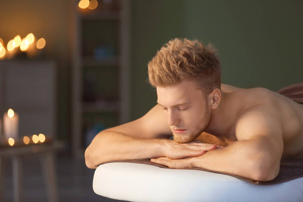 Handsome young man relaxing in spa salon - Photo, Image