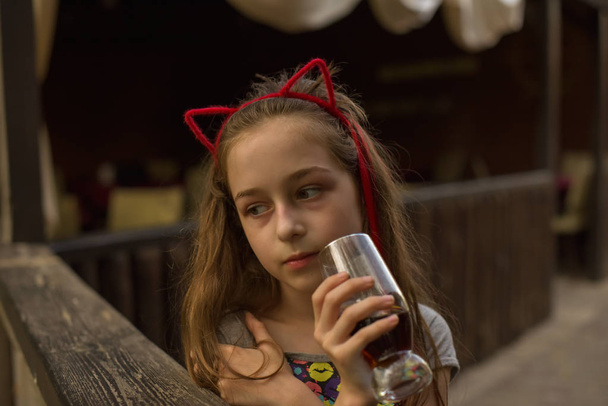 niña bebe una bebida marrón
 - Foto, Imagen