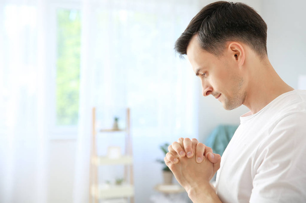 Θρησκευόμενος άνθρωπος προσεύχεται στο Θεό στο σπίτι - Φωτογραφία, εικόνα