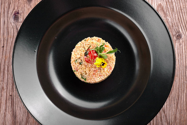 Couscous on a black plate - Фото, зображення