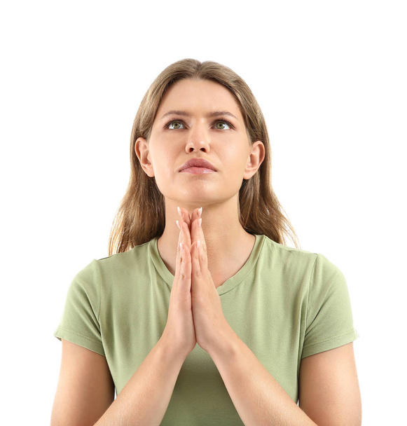 Θρησκευτική νεαρή γυναίκα προσεύχεται στο Θεό σε λευκό φόντο - Φωτογραφία, εικόνα