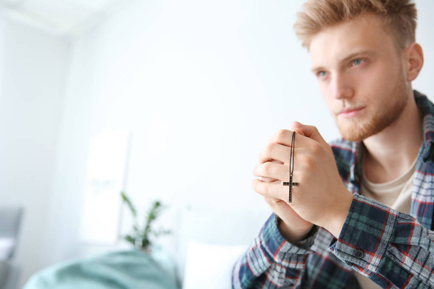 Religious young man praying to God at home - 写真・画像