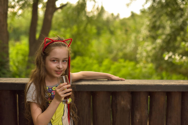 Маленькая девочка пьет коричневый напиток
 - Фото, изображение