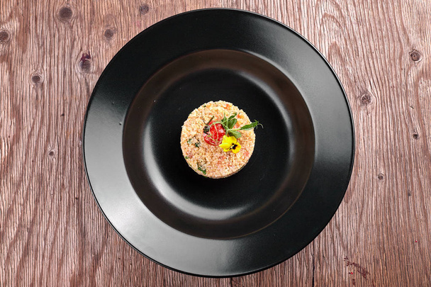 Couscous auf einem schwarzen Teller - Foto, Bild