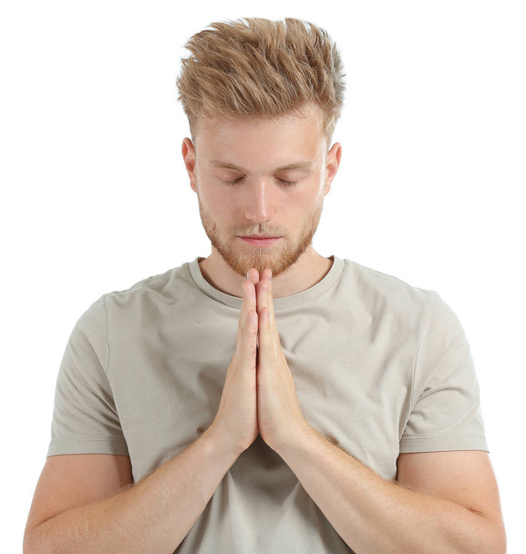 Religious young man praying to God on white background - Foto, Imagem