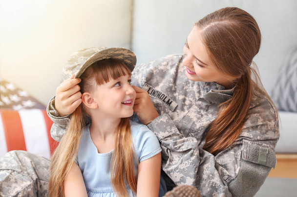 Ευτυχισμένος γυναίκα στρατιώτης με την κόρη της στο σπίτι - Φωτογραφία, εικόνα