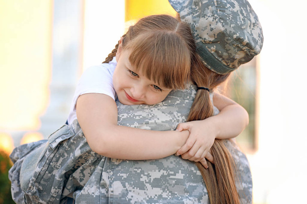 Happy little girl meeting her military mother outdoors - Photo, Image