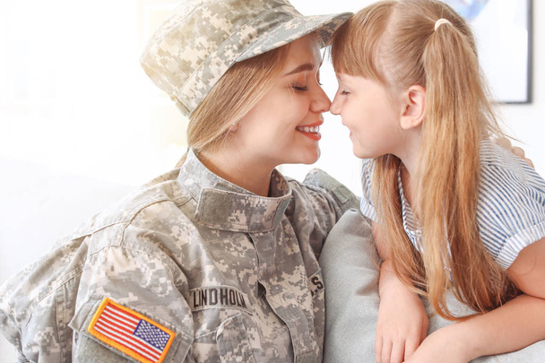 Ευτυχισμένος γυναίκα στρατιώτης με την κόρη της στο σπίτι - Φωτογραφία, εικόνα