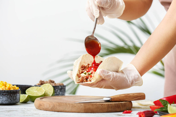 Woman preparing tasty fresh tacos in kitchen - Photo, image