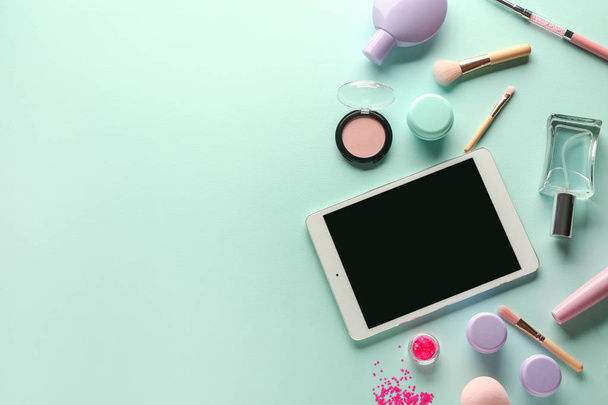 moderner Tablet-Computer und Kosmetik auf farbigem Hintergrund - Foto, Bild
