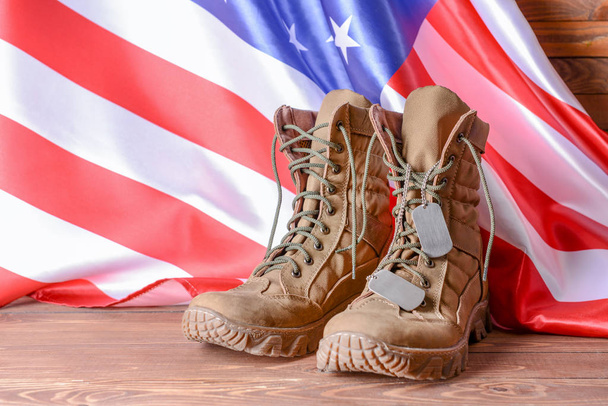 Vojenská obuv a vlajka USA na dřevěném stole - Fotografie, Obrázek
