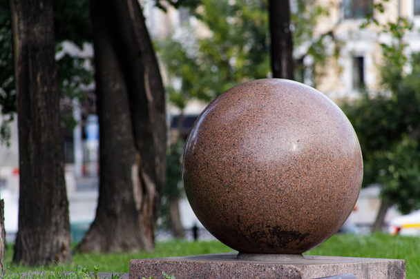 Αρχιτεκτονική λεπτομέρεια: μεγάλη πέτρινη μπάλα σε ένα πεζοδρόμιο. - Φωτογραφία, εικόνα