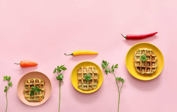 Тарілки зі смачними вафлями, травами та перець чилі на кольоровому фоні
 - Фото, зображення