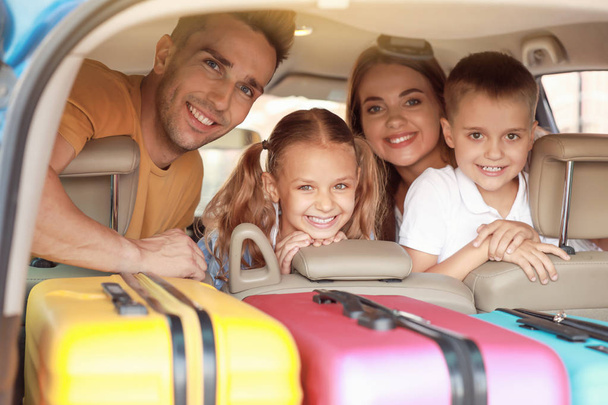 Familia feliz en coche con equipaje embalado
 - Foto, imagen
