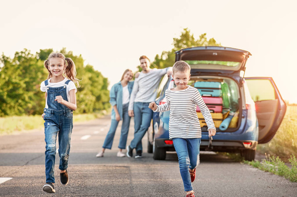 Щасливі діти та їхні батьки біля машини на відкритому повітрі
 - Фото, зображення