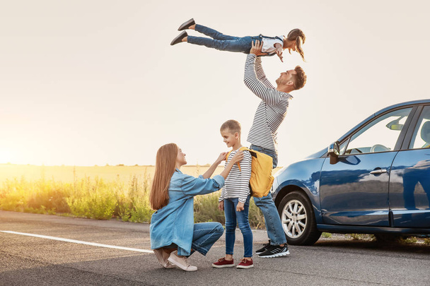 Les parents disent au revoir à leurs enfants près de la voiture
 - Photo, image