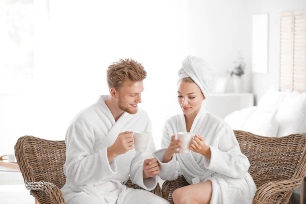 Mañana de feliz pareja joven en batas de baño en casa
 - Foto, Imagen