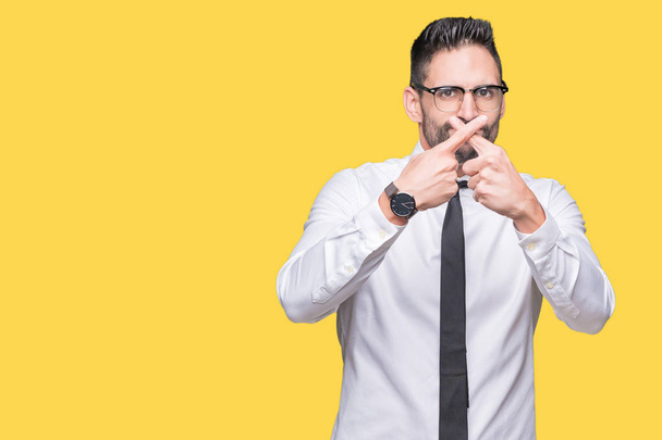 Young handsome business man wearing glasses over isolated background Rejection expression crossing fingers doing negative sign - Foto, Imagen