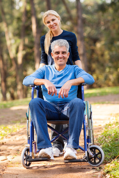 wife taking her disabled husband for a walk - Foto, Bild