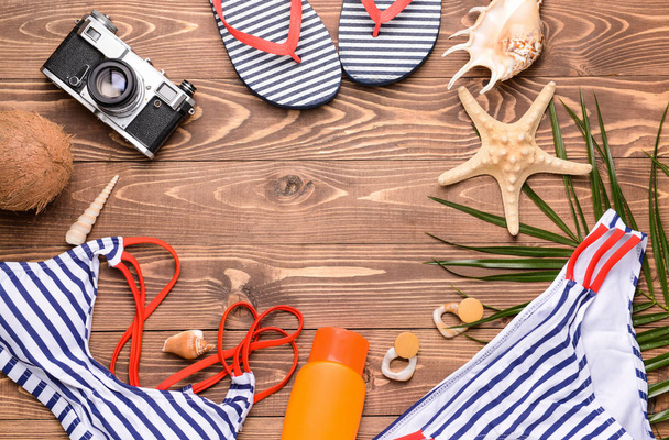 Composition with beach accessories and photo camera on wooden background - Fotoğraf, Görsel