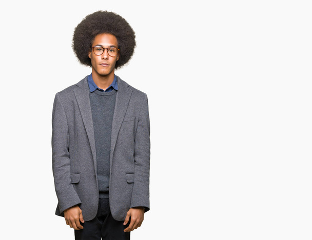 Young african american business man with afro hair wearing glasses with serious expression on face. Simple and natural looking at the camera. - Photo, Image