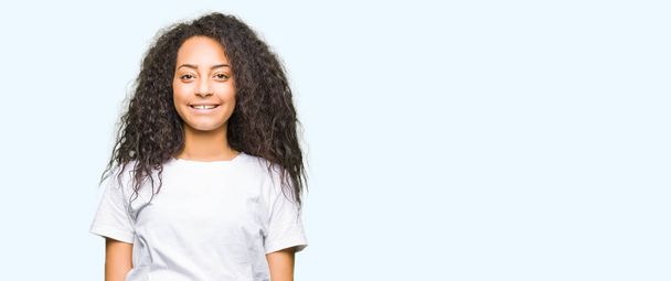 Young beautiful girl with curly hair wearing casual white t-shirt with a happy and cool smile on face. Lucky person. - Fotoğraf, Görsel