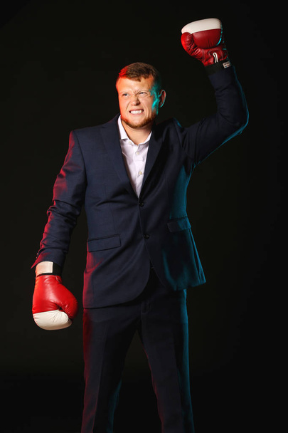 Бізнесмен в боксерських рукавичках на темному тлі
 - Фото, зображення