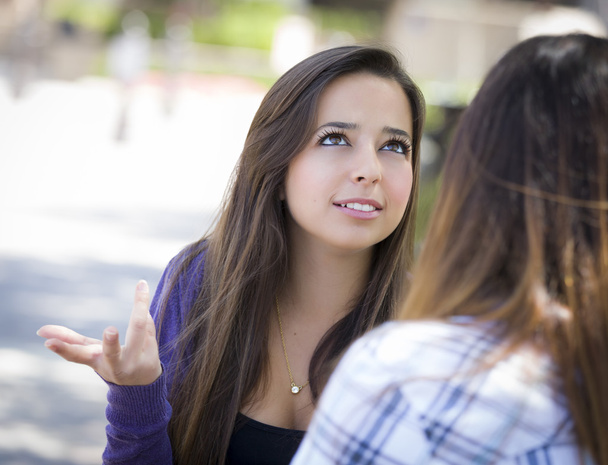 expressieve jonge gemengd ras vrouw zitten en praten met meisje - Foto, afbeelding