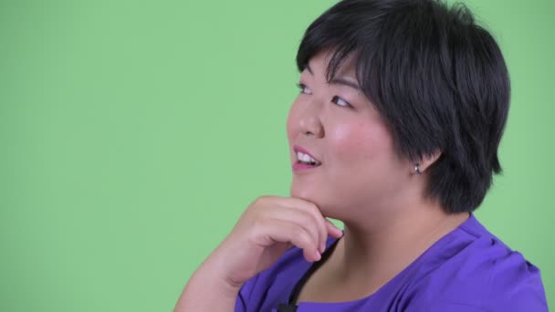 Closeup profile view of happy young overweight Asian woman thinking - Footage, Video