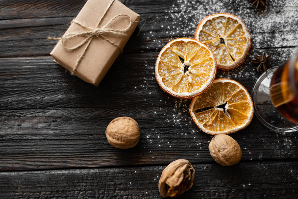Noel arka plan, portakal dilimleri, ceviz ve sarılmış hediyeler ahşap bir masa üzerinde yalan - Fotoğraf, Görsel