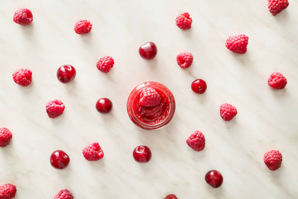 Jar of raspberry jam with berries on light background - Photo, Image