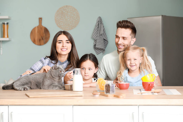 Happy family with cute cat in kitchen - Photo, Image