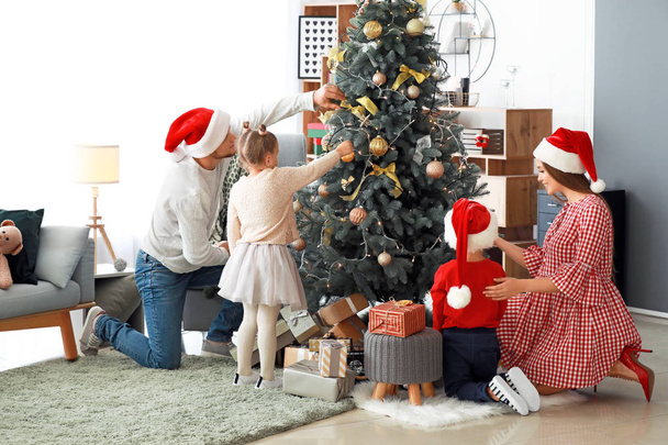 счастливая семья украшая елку дома - Фото, изображение
