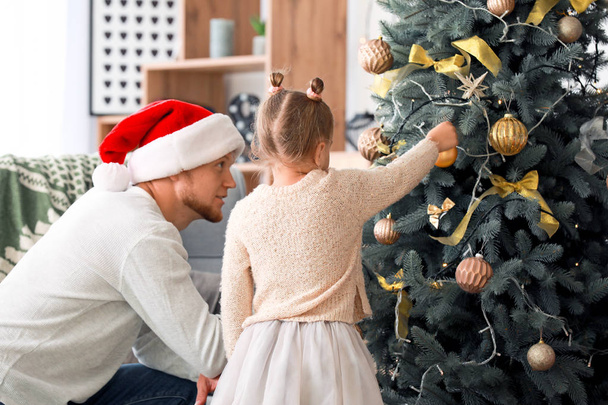 Happy family decorating Christmas tree at home - Photo, Image
