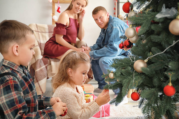 Bambini felici che decorano l'albero di Natale a casa
 - Foto, immagini