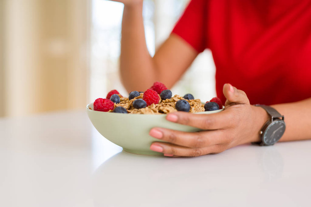 Close up of young woman eating healthy cereals and berries for b - Foto, Imagem