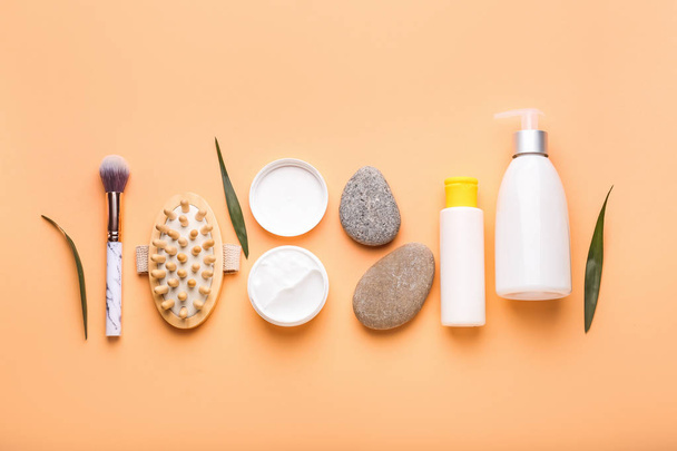 Kozmetikai termékek, masszázs kefe és Spa kövek színes háttérrel - Fotó, kép