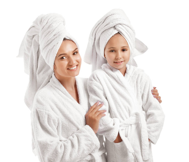 Mutter und ihre kleine Tochter in Bademänteln auf weißem Hintergrund - Foto, Bild