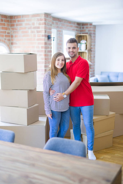 Young beautiful couple in love around cardboard boxes moving to  - Foto, afbeelding