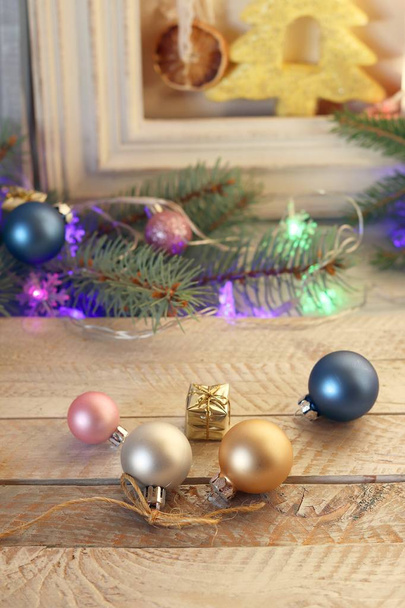 Διακόσμηση, φωτισμένο χριστουγεννιάτικο δέντρο, Χριστουγεννιάτικα παιχνίδια και φέτες αποξηραμένου λεμονιού σε ξύλινο τραπέζι, εποχιακές χειμερινές διακοπές - Φωτογραφία, εικόνα