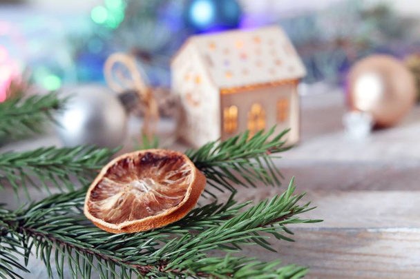 Декор, освітлена ялинка, новорічні іграшки та скибочки сушеного лимона на дерев'яному столі, сезонні зимові канікули
 - Фото, зображення