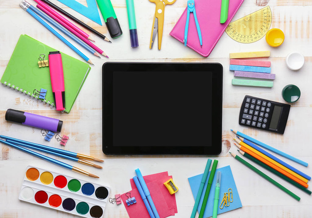 Schulbedarf mit Tablet-Computer auf weißem Holzhintergrund - Foto, Bild