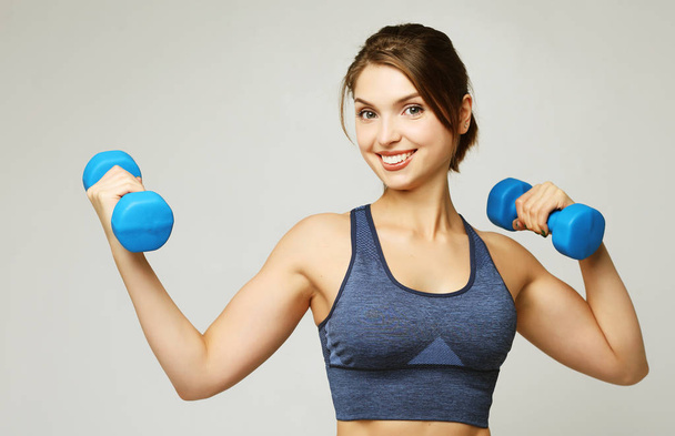 sport and people concept: Young girl athlete, fitness with dumbbells on white background - Photo, image